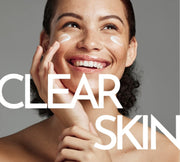 Female model smiling posed with cream on her cheeks.